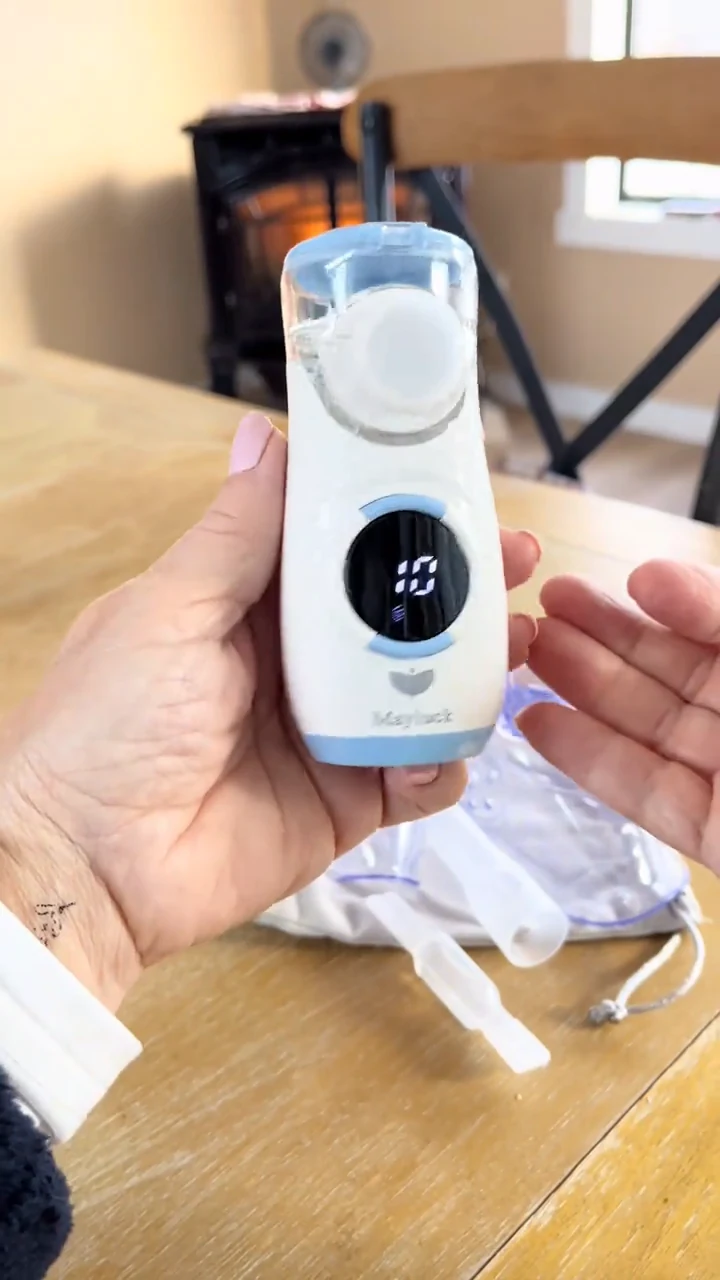 An original creator video frame showing a white and pale-blue MY135 held in a hand, with its rounded display visible